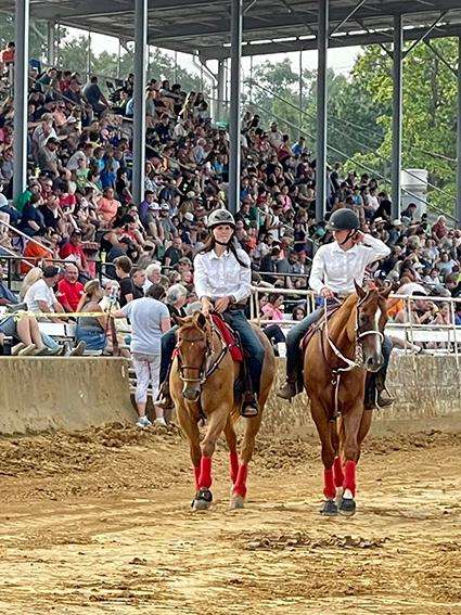Riders performing in front of a crowd at a horse show