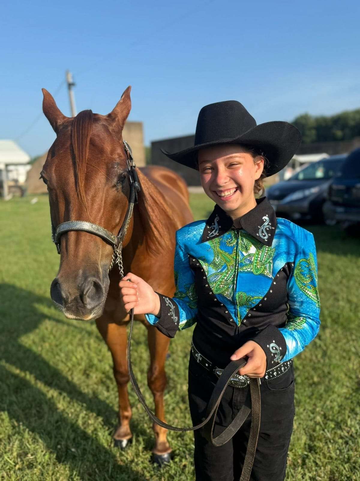 4-H rider in western show attire with her chestnut horse