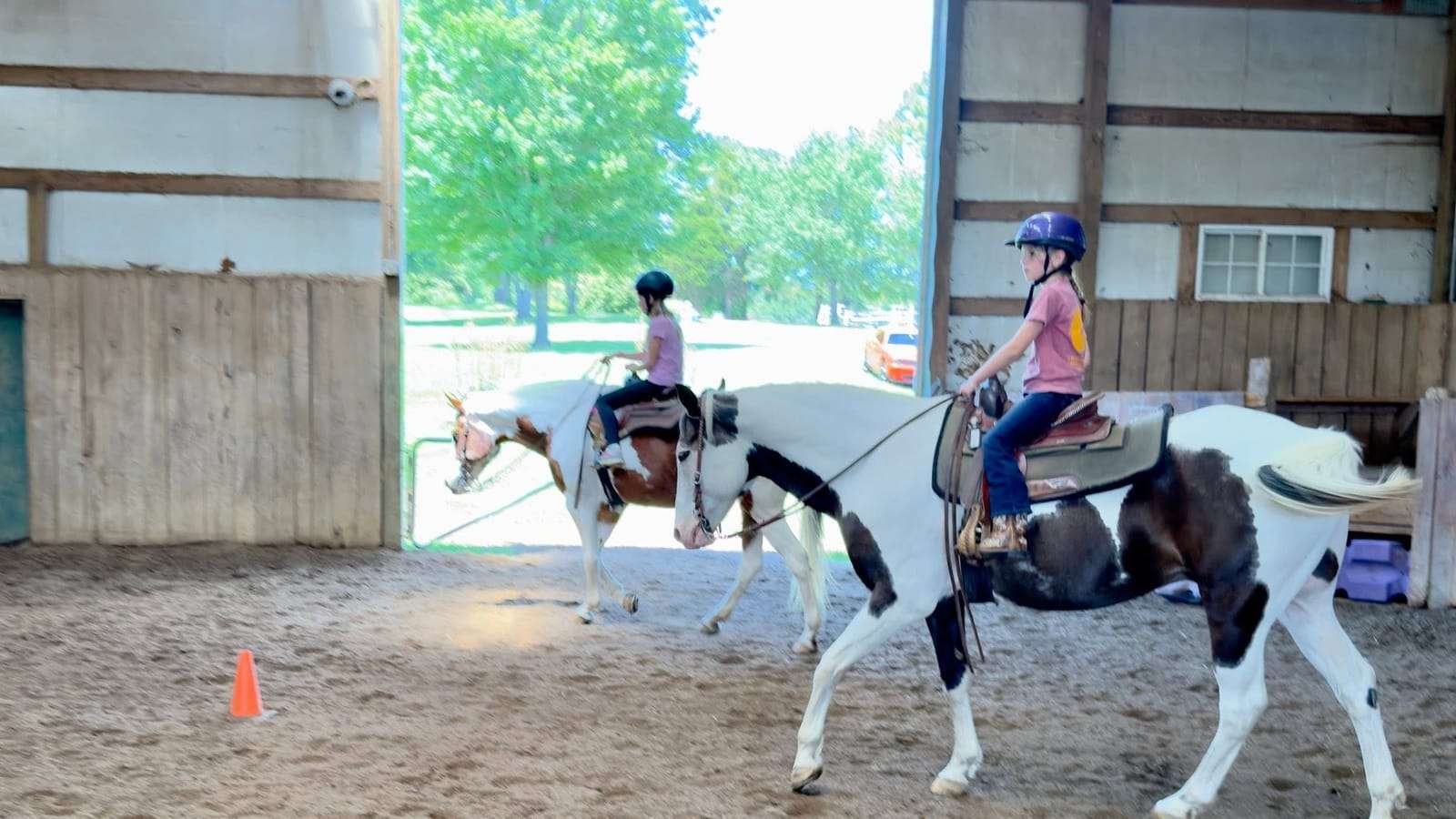 Camper riding a paint horse around a cone