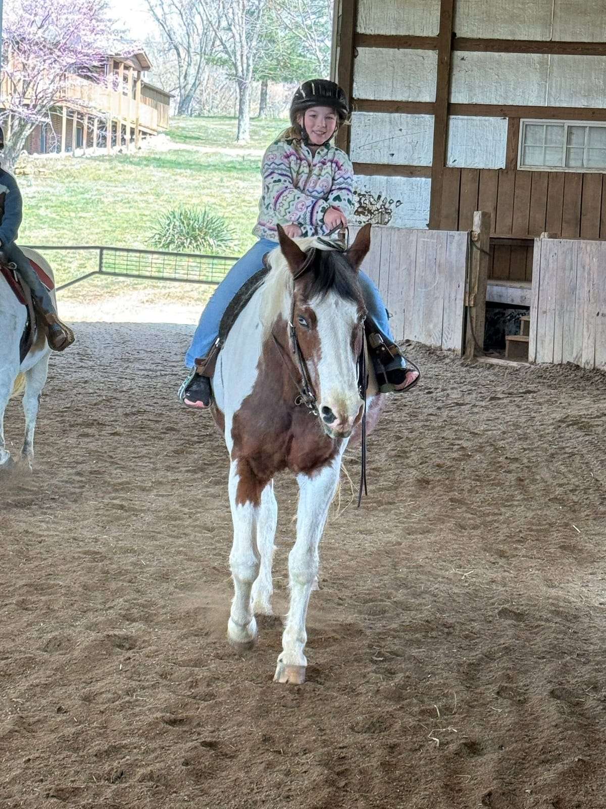 Young camper riding a paint horse at a Night Sun Stables camp in Evansville