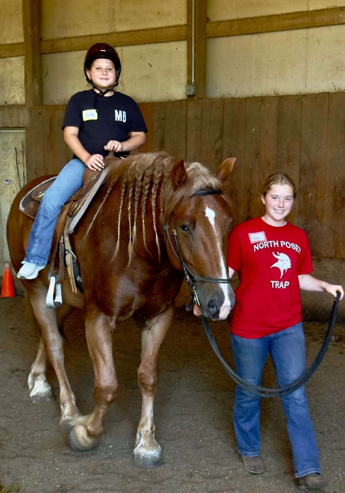 An instructor leads a young rider on horseback during a lesson at Night Sun Stables in Evansville